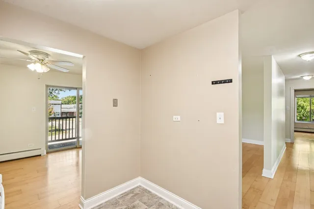 a view of a room with wooden floor and a bathroom