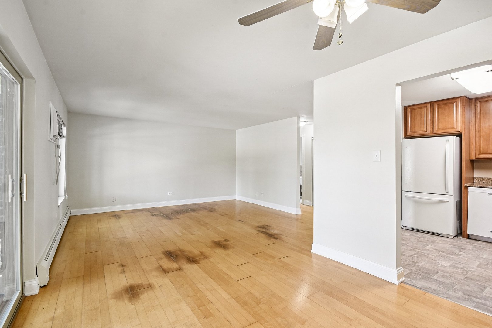 461 North Jonathan Drive, Unit 202 Palatine, IL 60074 - Photo 8 of 23 an empty room with chandelier fan and kitchen view