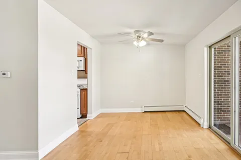 an empty room with a window and a ceiling fan