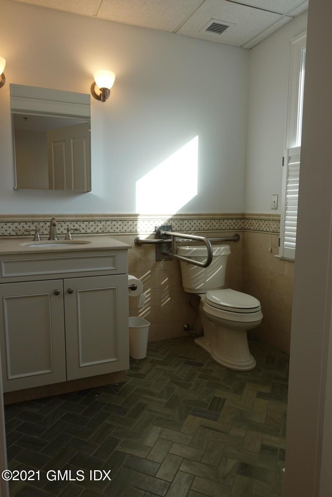 23 Benedict Place, Unit 3 Greenwich, CT 06830 - Photo 4 of 16 a bathroom with a granite countertop toilet a mirror and a sink
