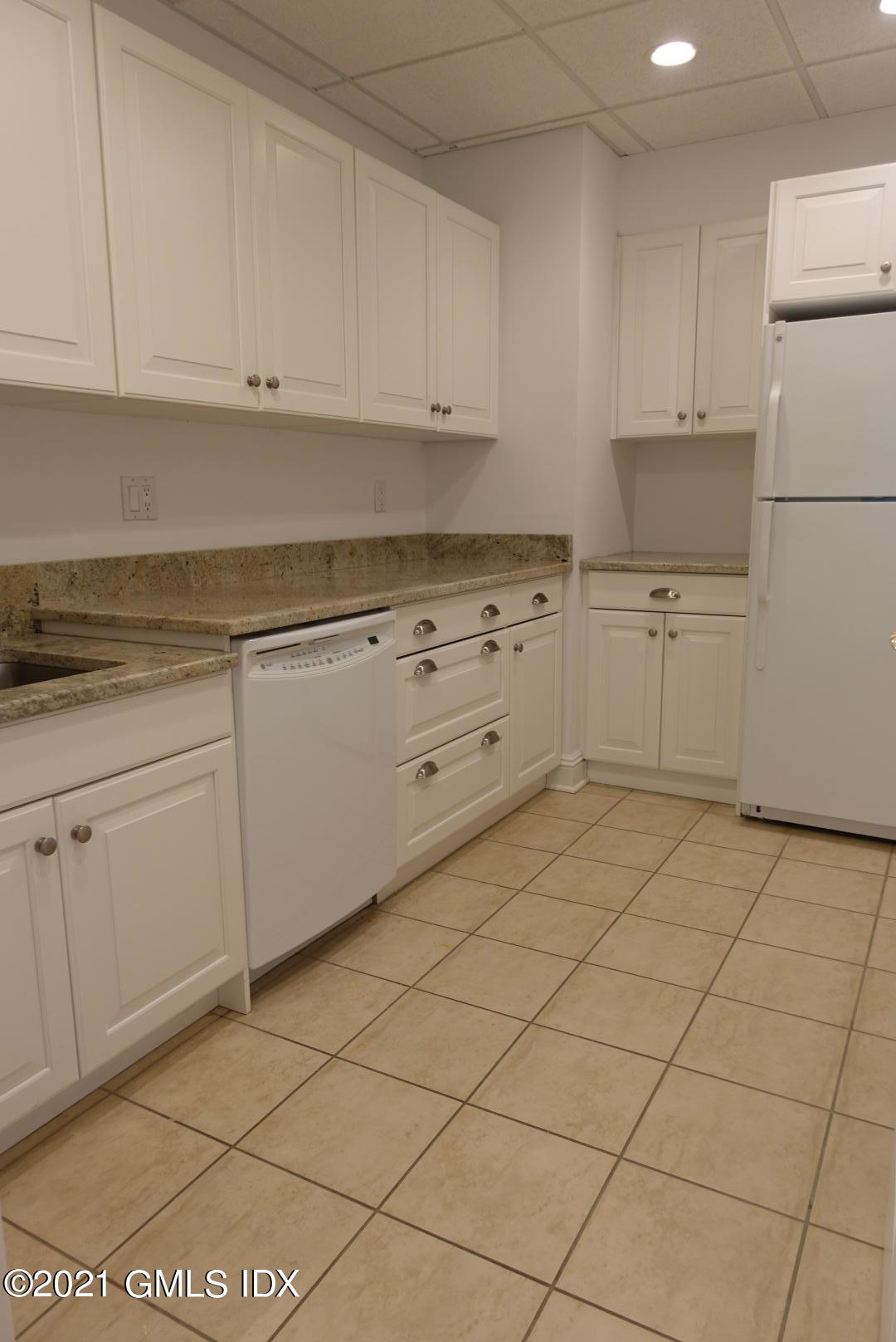 23 Benedict Place, Unit 3 Greenwich, CT 06830 - Photo 7 of 16 a kitchen with granite countertop white cabinets and stainless steel appliances