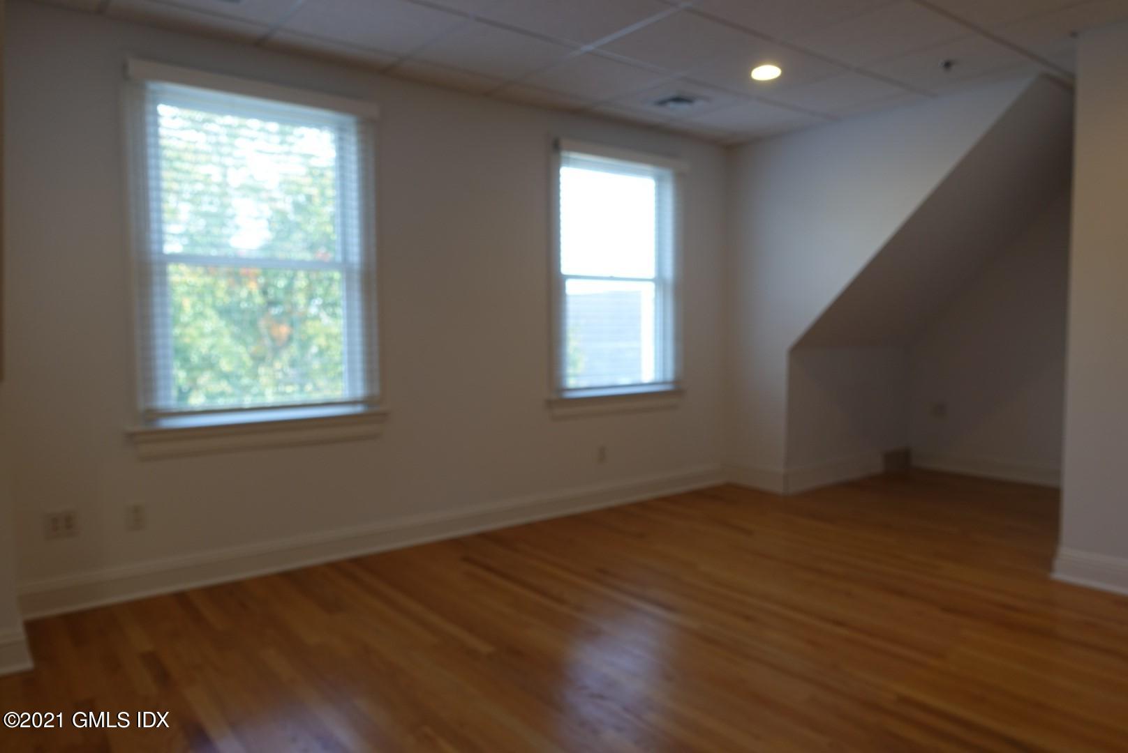 23 Benedict Place, Unit 3 Greenwich, CT 06830 - Photo 8 of 16 an empty room with wooden floor and windows