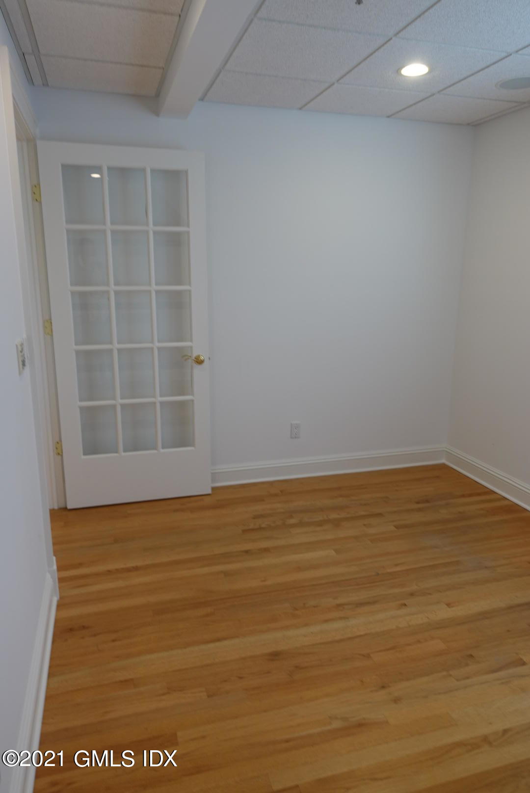 23 Benedict Place, Unit 3 Greenwich, CT 06830 - Photo 10 of 16 a view of an empty room with wooden floor and a window
