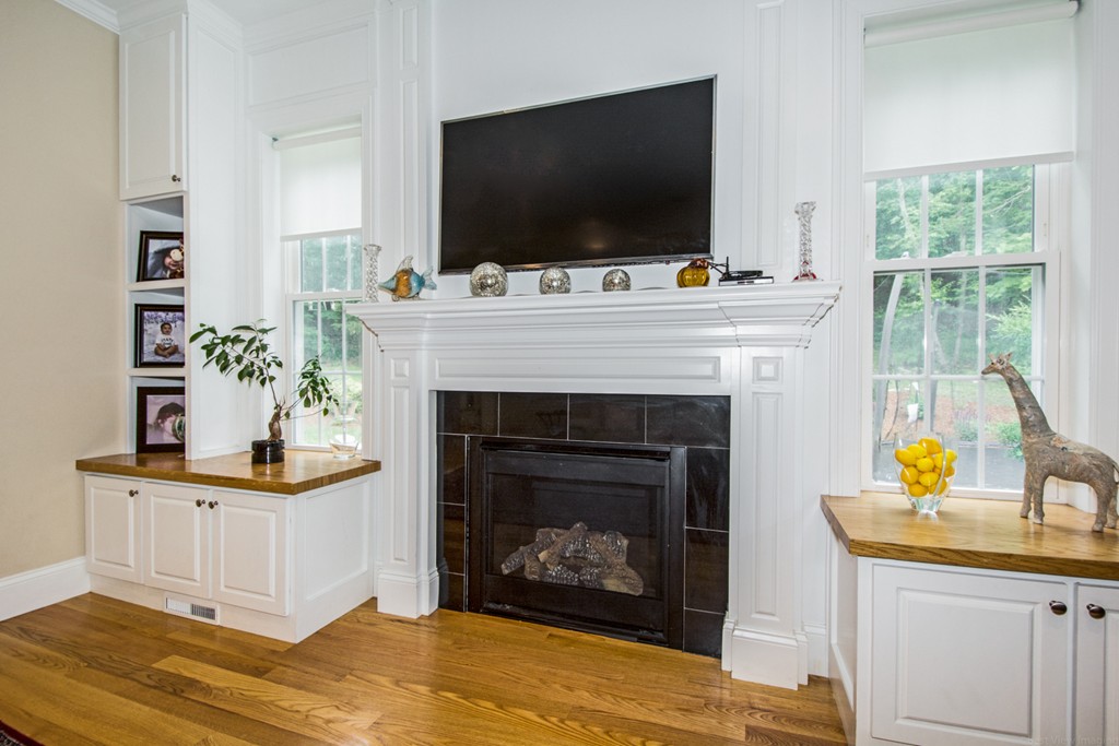 127 Lowell Street Lexington, MA 02420 - Photo 11 of 30 a living room with furniture a flat screen tv and a fireplace