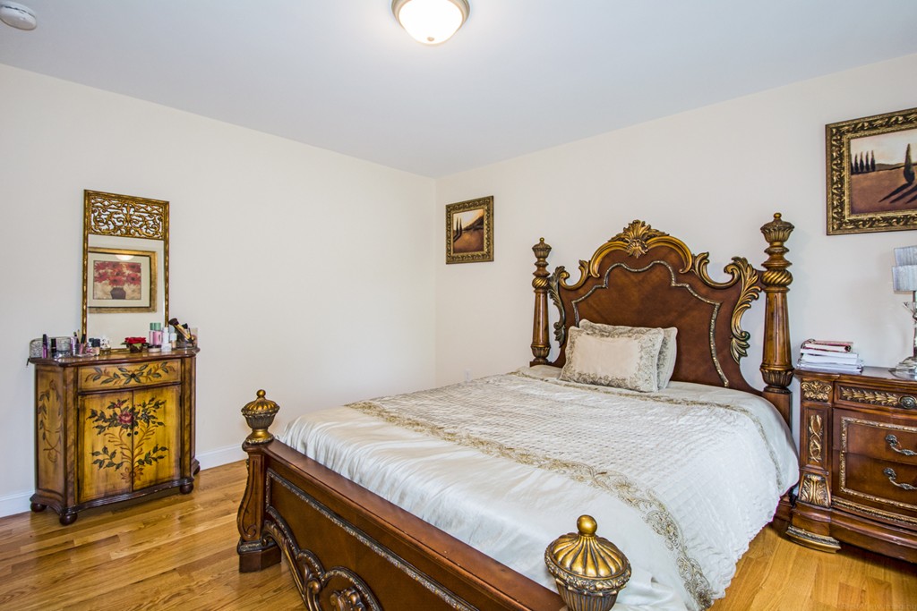 127 Lowell Street Lexington, MA 02420 - Photo 21 of 30 a bedroom with a bed and wooden floor