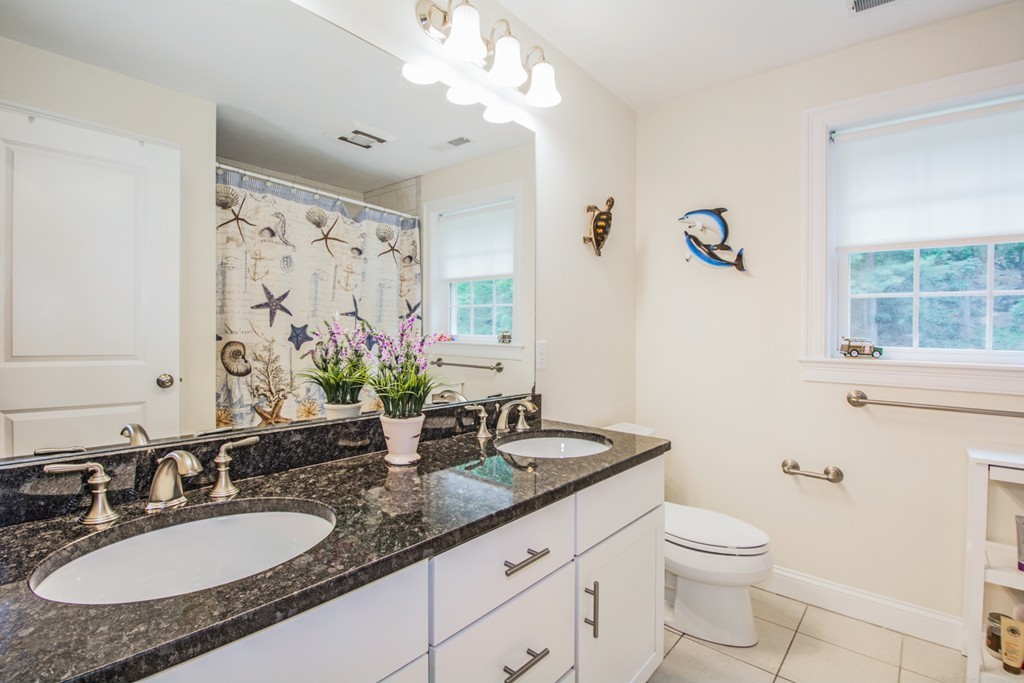 127 Lowell Street Lexington, MA 02420 - Photo 24 of 30 a bathroom with a granite countertop sink a toilet and mirror