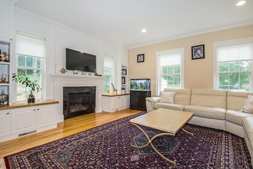 127 Lowell Street Lexington, MA 02420 - Photo 10 of 30 a living room with furniture a flat screen tv and a fireplace