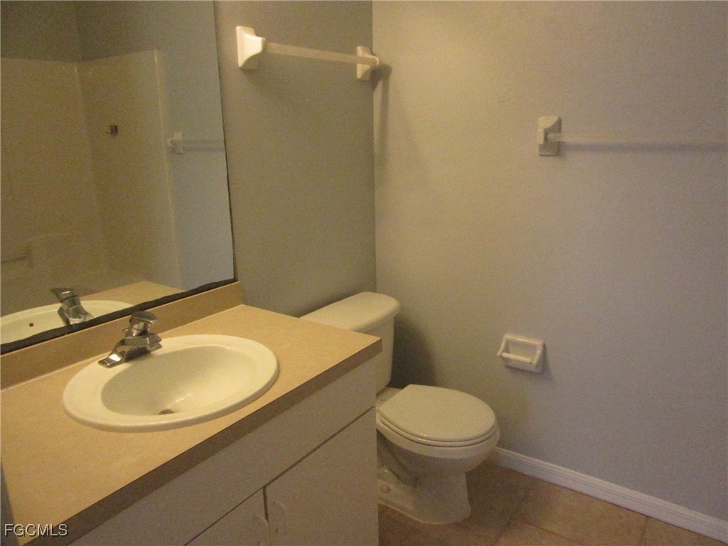 4544-4546 28th Street Southwest Lehigh Acres, FL 33973 - Photo 17 of 23 a bathroom with a sink a toilet and a mirror