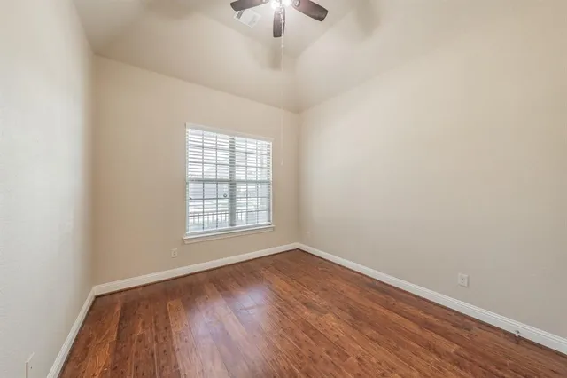 an empty room with a window and wooden floor