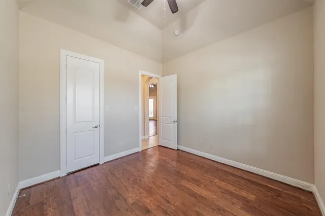 a view of an empty room with wooden floor