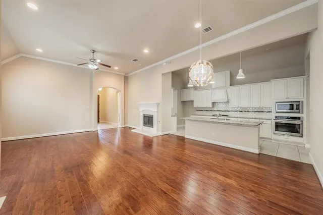 a large kitchen with granite countertop a large counter top a sink stainless steel appliances and cabinets