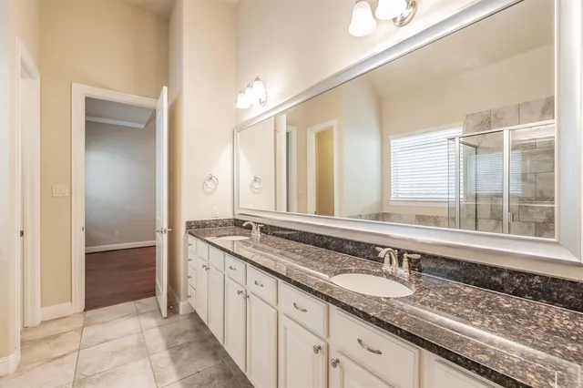 a bathroom with a granite countertop sink and a mirror