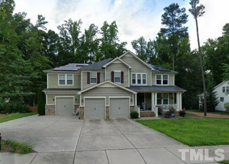 a front view of a house with a garden and trees
