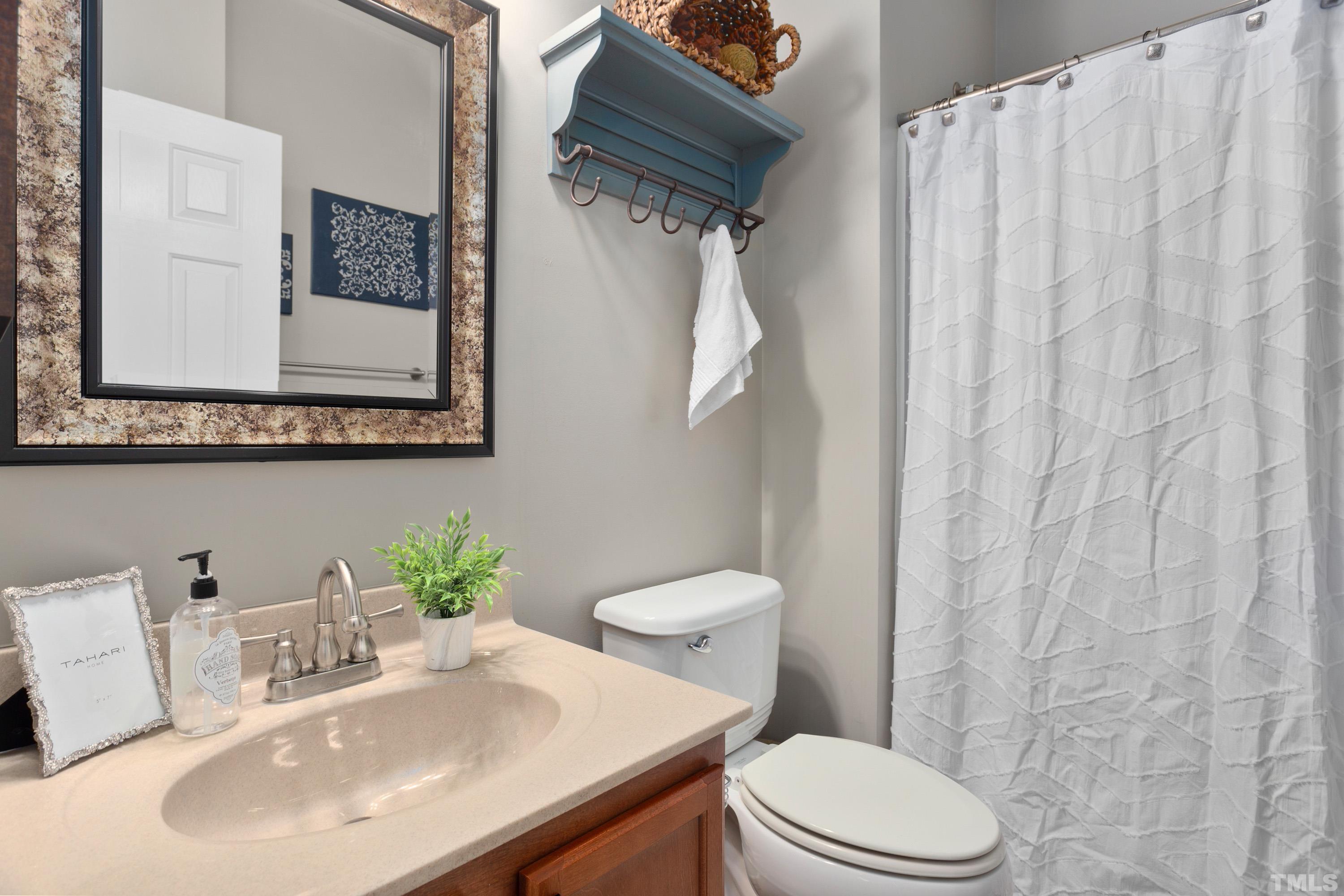13016 Saxon Way Raleigh, NC 27613 - Photo 36 of 49 a bathroom with a sink a toilet and a mirror