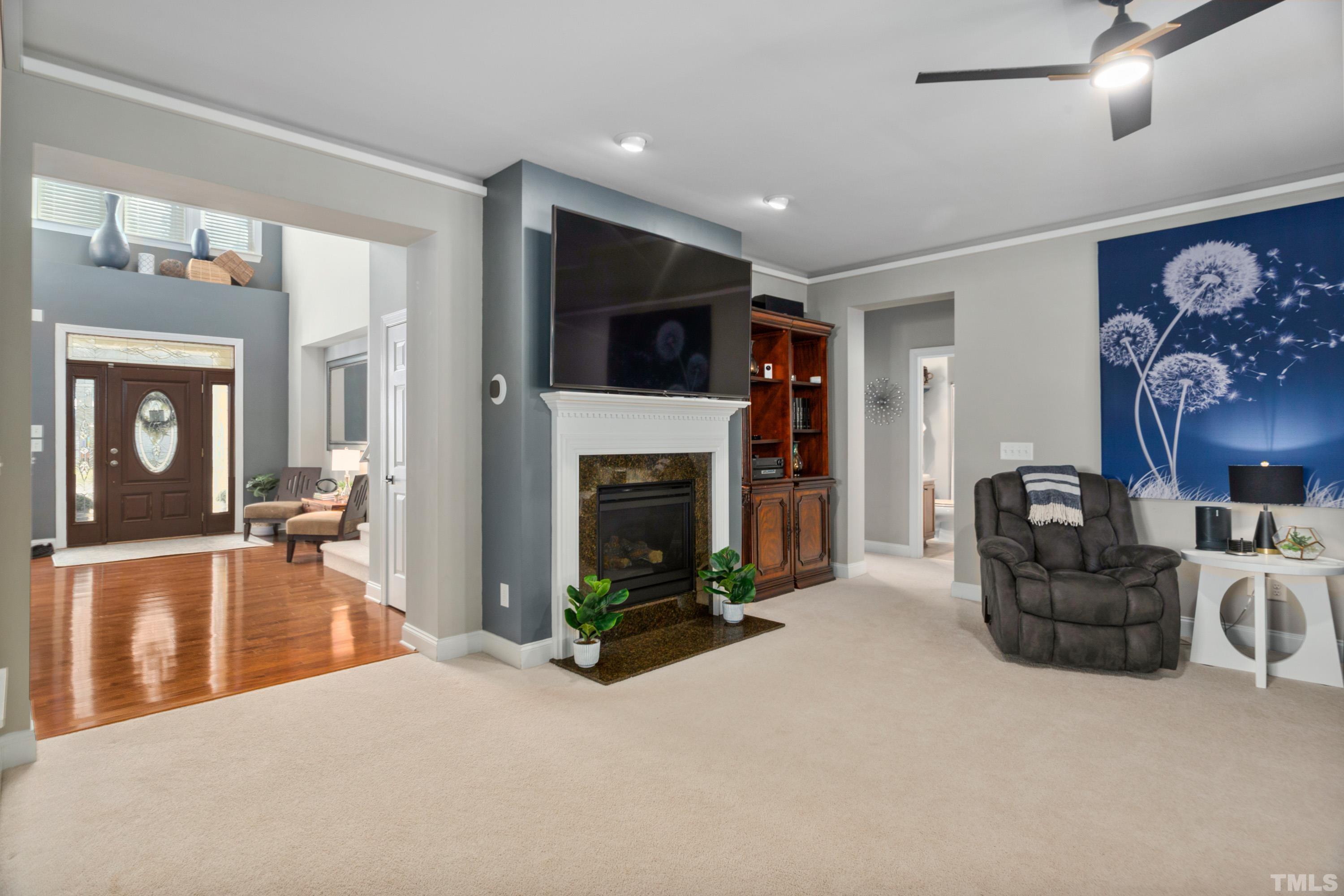 13016 Saxon Way Raleigh, NC 27613 - Photo 41 of 49 a living room with furniture a flat screen tv and a fireplace