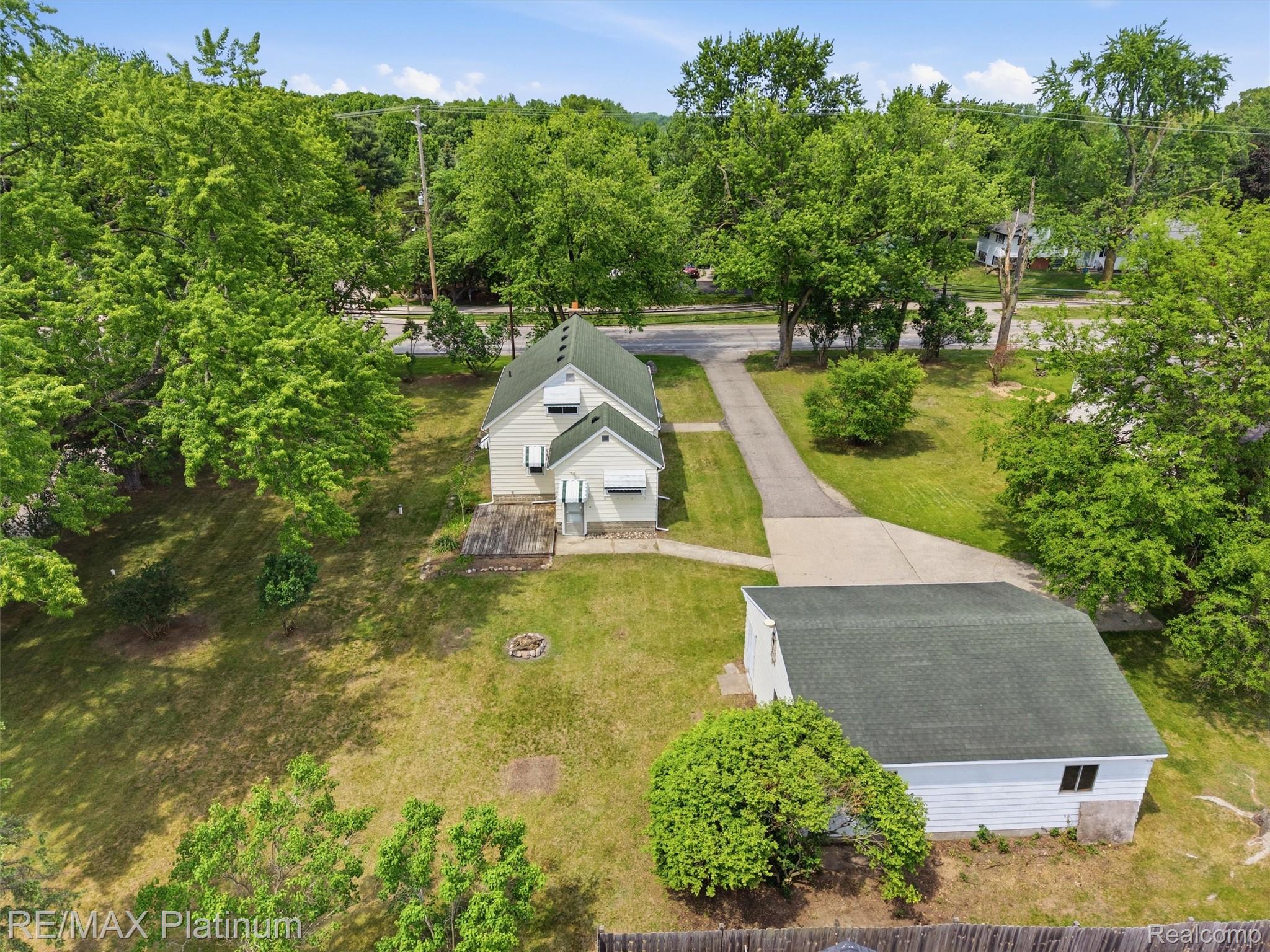 6335 Silver Lake Road Linden, MI 48451 - Photo 57 of 61 Property exterior featuring white siding and a green shingle roof