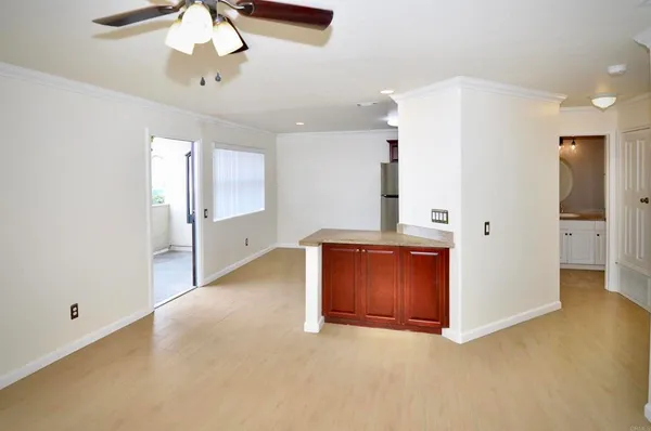 en empty room with a chandelier and wooden floor