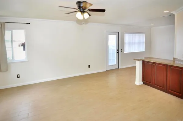 an empty room with windows and fan