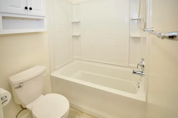 a white bath tub sitting next to a white toilet