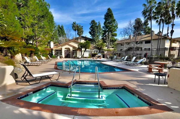 a view of a swimming pool with lawn chairs under an umbrella