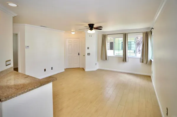 a view of a big room with windows and chandelier fan
