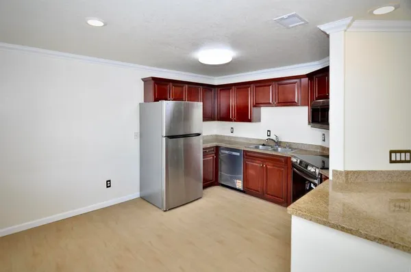 a kitchen with stainless steel appliances granite countertop a refrigerator and a sink