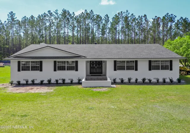 a aerial view of a house with swimming pool and a yard