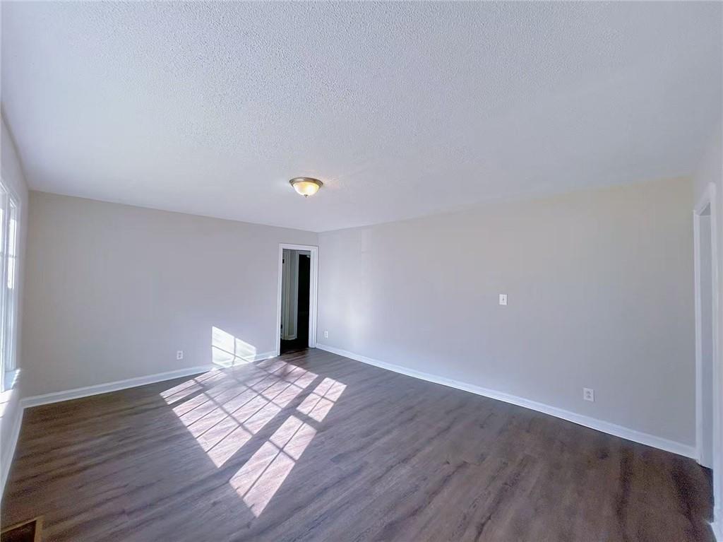 2126 Ivydale Street Atlanta, GA 30344 - Photo 3 of 11 a view of an empty room with wooden floor and a window