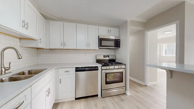 a kitchen with appliances a sink and cabinets