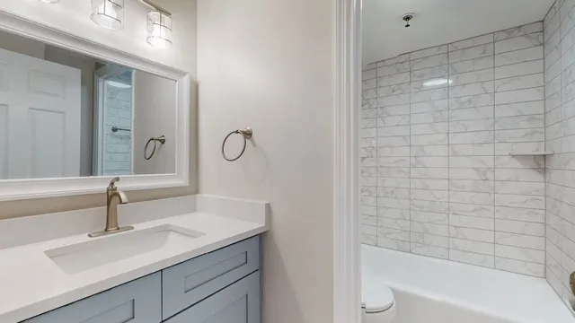 a bathroom with a granite countertop sink a toilet and bathtub