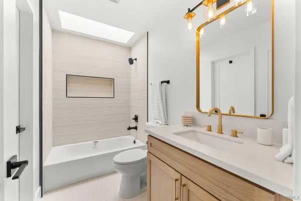 a bathroom with a granite countertop sink a toilet and a large mirror