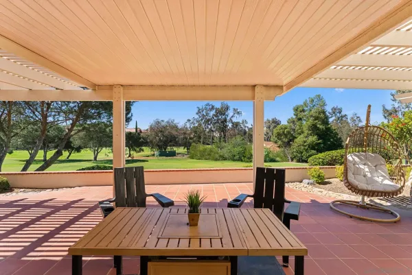 a view of a patio with lawn chairs next to a yard