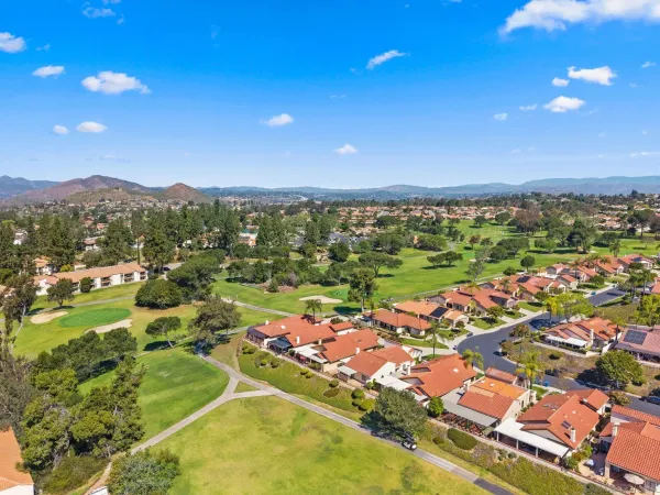 an aerial view of residential houses with outdoor space and street view