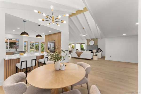 a living room with furniture kitchen view and a chandelier