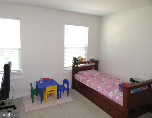a bedroom with a bed a window and dresser