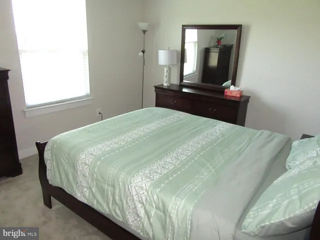 a bedroom with a bed and a flat tv screen on a dresser