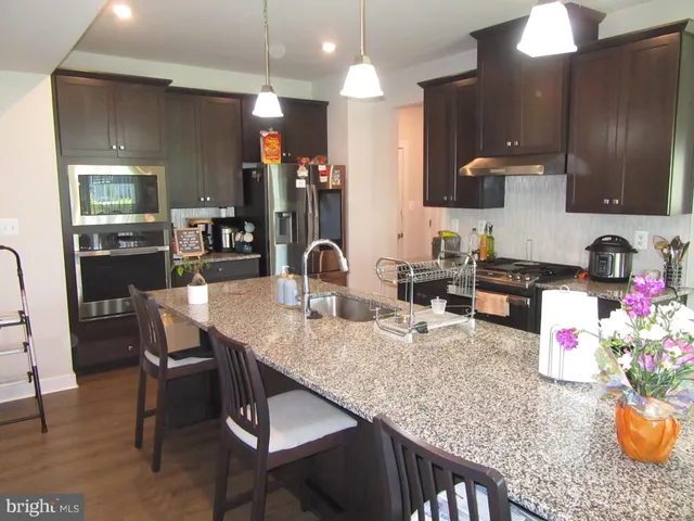 a kitchen with granite countertop lots of wooden furniture