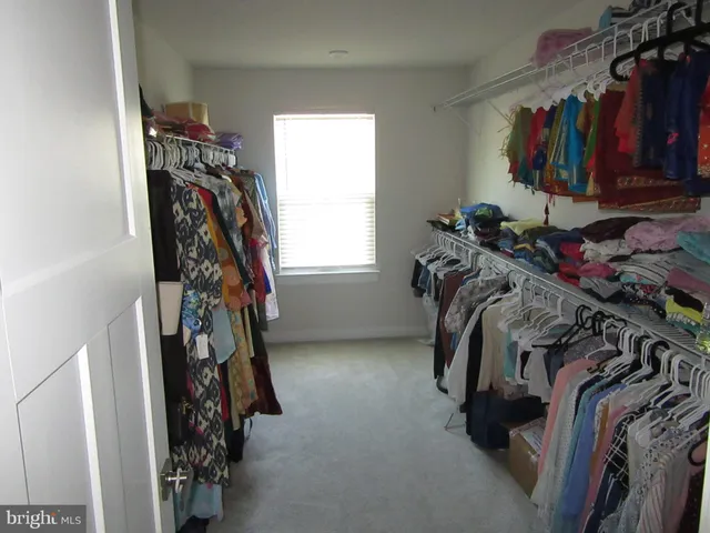 a view of walk in closet with clothes