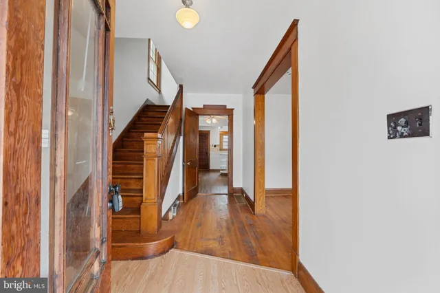a view of a hallway with wooden floor and staircase