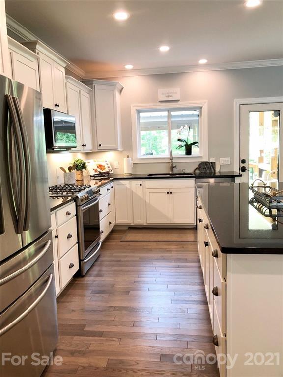 592 Cabin Creek Road Biscoe, NC 27209 - Photo 6 of 20 a large kitchen with stainless steel appliances granite countertop a stove refrigerator and a microwave