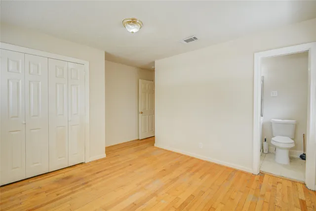 a view of a room with wooden floor and bathroom view