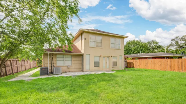 a view of a house with backyard and a tree