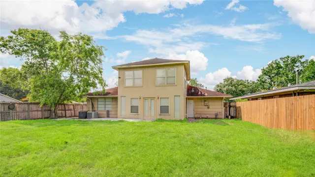 a view of a house with a big yard and large tree