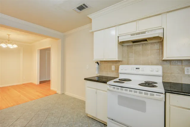 a kitchen with a stove and white cabinets