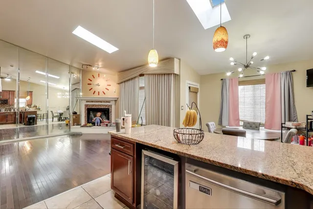 a kitchen with kitchen island granite countertop a sink a counter top space and living room view