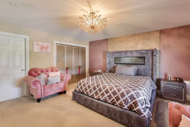 a bedroom with a bed and a chandelier