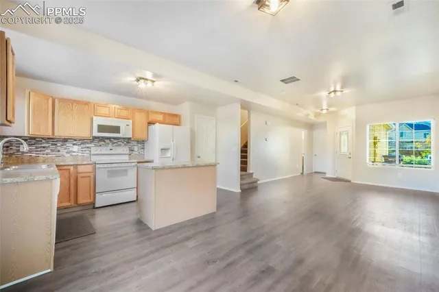 a kitchen with a refrigerator and white cabinets