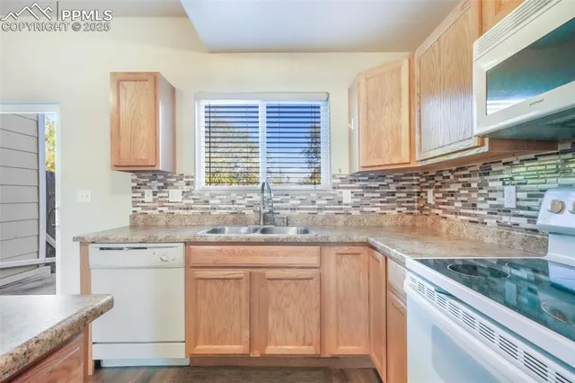 a kitchen with granite countertop white cabinets and white appliances