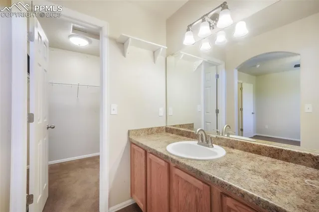 a bathroom with a granite countertop sink a mirror and a shower