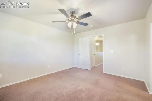 an empty room with closet and ceiling fan